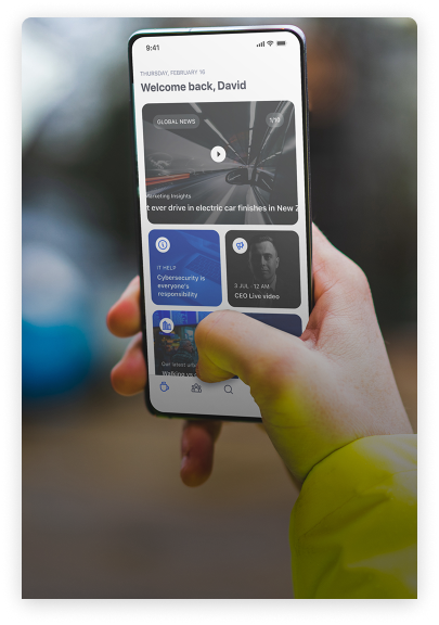 A person in a yellow sleeve holding a smartphone displaying a personalized news app home screen. The screen shows various news cards, including topics like electric cars, cybersecurity, and a live CEO video. The background is blurred.